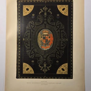 May include: An antique book cover with a black background and ornate gold detailing. The cover features a central oval design with a coat of arms in red, gold, and white. The corners have gold accents. The text at the bottom reads "PLATE XVII. SHIRAT, NAVIGATIONS ET PEREGRINATIONES ORIENTALES. 1708, 1765."
