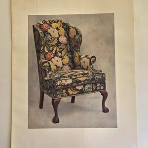 May include: A vintage wingback chair with a floral pattern in shades of yellow, pink, and green on a dark background. The chair has curved arms, a high back, and dark wooden legs with a clawfoot design. The image is printed on a cream-colored paper.