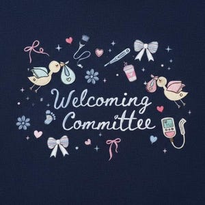 Op de afbeelding: Marineblauw geborduurd ontwerp met de tekst "Welcoming Committee" en illustraties van ooievaars die bundels, harten, strikken, bloemen en medische apparatuur dragen. Het ontwerp is gedetailleerd met pastelkleuren en kleine sterren.