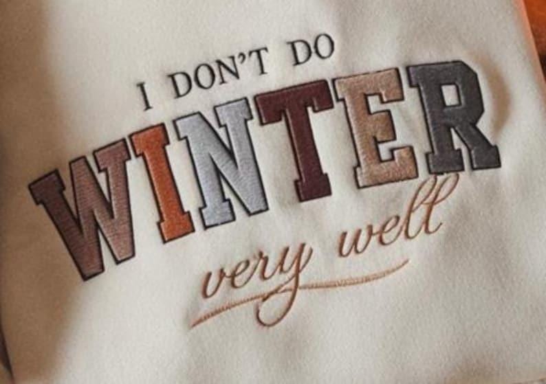 Puede incluir: Sudadera color crema con la frase bordada "I DON'T DO WINTER very well." El texto est&aacute; en una mezcla de colores, incluyendo marr&oacute;n, naranja, gris y beige. La sudadera tiene un estilo casual y relajado.