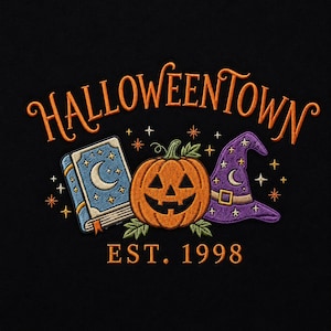 May include: An embroidered design on a black background featuring the orange text HALLOWEENTOWN above a blue spellbook with a crescent moon, a central orange jack-o'-lantern, and a purple witch hat with stars, with the orange text EST. 1998 below.