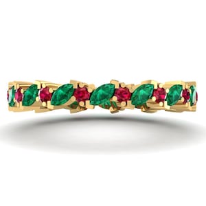 May include: A gold band ring with alternating emerald and ruby marquise-shaped gemstones.