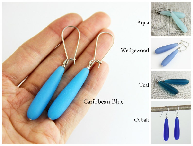 May include: A pair of dangle earrings with silver hooks and teardrop-shaped glass beads in various shades of blue, including aqua, Wedgwood, teal, Caribbean blue, and cobalt.