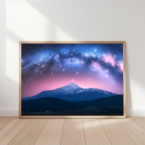 Könnte beinhalten: Gerahmter Druck mit einem lebendigen Nachthimmel und der Milchstraße. Das Bild zeigt eine Bergkette vor einem Hintergrund aus blauen, rosa und violetten Farbtönen, mit einem Holzrahmen.