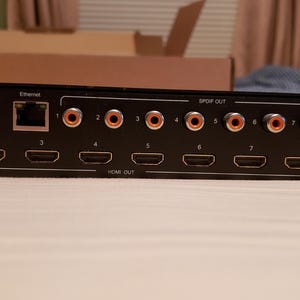 Puede incluir: Dispositivo electr&oacute;nico negro con m&uacute;ltiples puertos de salida HDMI y audio. Cuenta con conexiones RS-232, Ethernet y SPDIF OUT. El dispositivo tiene una entrada de CC y est&aacute; dise&ntilde;ado para aplicaciones audiovisuales.