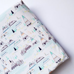 May include: White crib sheet with a blue and green pattern of stylized mountains and trees. The pattern is repeated throughout the sheet.