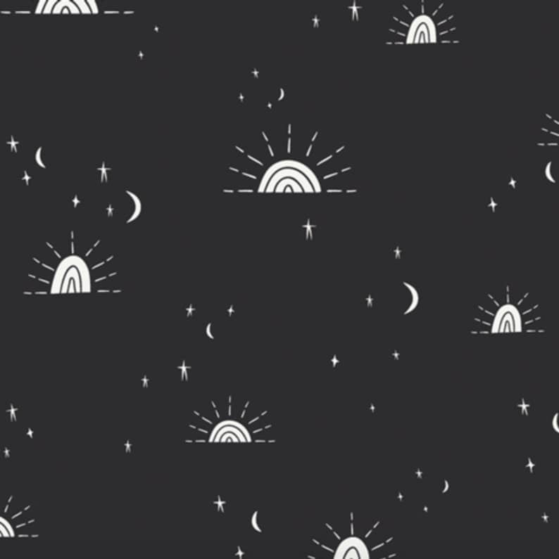 May include: A black fabric featuring a repeating white line-art pattern of suns rising over a horizon line, interspersed with various sizes of crescent moons and five-pointed stars scattered across the dark background in a celestial motif.