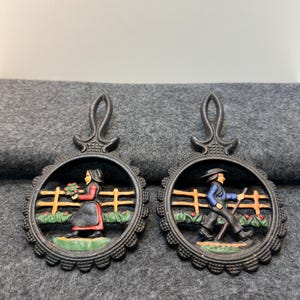 Vintage Dutch scene cast iron trivets - set of 2