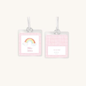 Op de afbeelding: Twee roze en witte gingham bagage-etiketten met een regenboog- en wolkenontwerp. Het eerste etiket heeft de naam "Miller James" erop gedrukt. Het tweede etiket heeft het telefoonnummer "555-123-4567" en de tekst "RUBYLA Design" erop gedrukt.