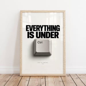 Peut inclure: Une affiche encadrée avec le texte noir EVERYTHING IS UNDER au-dessus d'une touche Ctrl de clavier d'ordinateur gris clair. Sous la touche, le texte STAY IN CONTROL est imprimé en petite police. Le cadre est en bois de couleur claire.