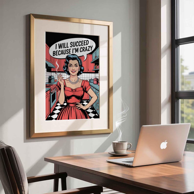 May include: Pop art style framed print featuring a woman in a red dress holding a cigarette in a kitchen setting. The speech bubble says, "I WILL SUCCEED BECAUSE I'M CRAZY." The print is in a gold frame, hanging on a wall above a wooden desk.