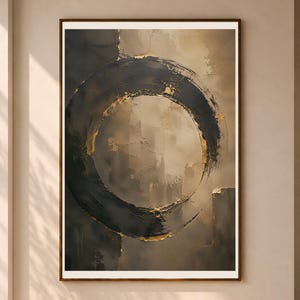 Könnte beinhalten: Ein gerahmtes Wandbild mit einem großen, texturierten schwarzen kreisförmigen Pinselstrich, der auf einem neutralen beige-grauen Hintergrund zentriert ist. Der Kreis zeigt sichtbare Pinselstriche mit dezenten Blattgoldakzenten an den Rändern, in einem dünnen braunen Rahmen.
