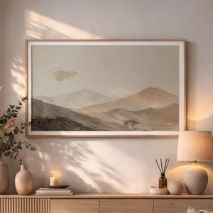 Könnte beinhalten: Ein rechteckiges gerahmtes Wandbild mit einer Landschaftsmalerei von geschichteten Bergen in Beige-, Creme- und sanften Brauntönen. Das Kunstwerk zeigt einen strukturierten, malerischen Stil mit einem hellen Himmel und einem dunkleren Vordergrund.