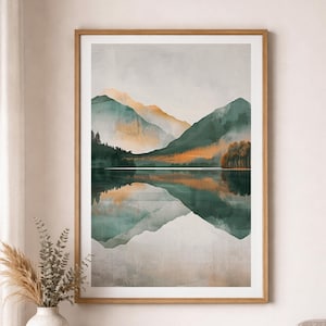Könnte beinhalten: Gerahmter Kunstdruck mit einer ruhigen Berglandschaft. Das Kunstwerk zeigt grüne und orangefarbene Berge, die sich in einem ruhigen See spiegeln. Der Druck ist in einem hellbraunen Holzrahmen gefasst und erzeugt eine natürliche Ästhetik.