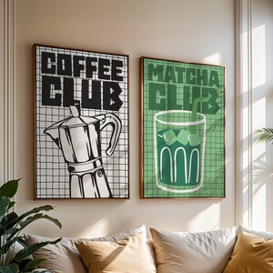 May include: Two rectangular wall art prints featuring grid backgrounds. The left print is white with black text reading COFFEE CLUB and a black moka pot illustration. The right print is green with dark green text reading MATCHA CLUB and a glass of matcha.