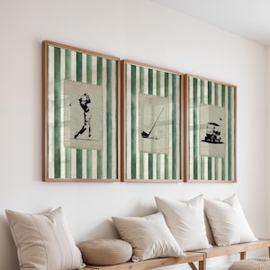 Puede incluir: Tres impresiones enmarcadas con temática de golf. Cada impresión presenta una ilustración en blanco y negro de equipo de golf o un golfista. El fondo es un patrón de rayas verdes y blancas. Los marcos son de color marrón claro.