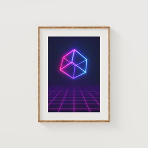 May include: Framed art print featuring a neon geometric cube in shades of pink and blue. The cube floats above a grid pattern, all set against a dark blue background. The artwork is encased in a wooden frame, suitable for wall decor.