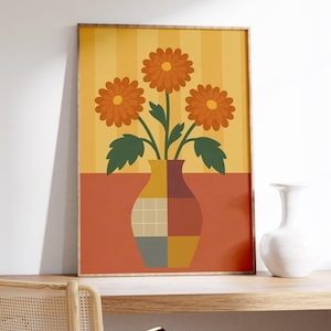 May include: A framed art print featuring a stylized floral arrangement. The artwork depicts three orange flowers with green leaves in a geometric vase. The background is divided into orange and yellow sections.