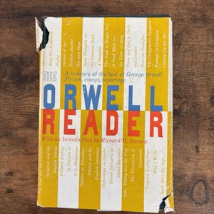 May include: The Orwell Reader book with a yellow, white, red, and blue cover. The title is in large blue and red letters. The book's cover features a treasury of essays, fiction, and reportage by George Orwell.