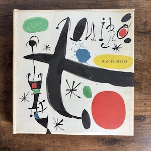 May include: A square book cover featuring abstract art with black, red, green, and blue shapes. The word "Miro" is written in black script. The text "JUAN PERUCHO" is on a yellow rectangle.