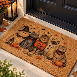 May include: A rectangular tan coir doormat featuring a printed illustration of five cats dressed in Halloween costumes, including a witch hat, a pumpkin sweater, and scarves, surrounded by small pumpkins, autumn leaves, and flying bats.