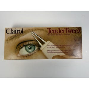 May include: Clairol Tender Tweez eyebrow tweezers. The packaging features an eye with green iris and a close-up of the tweezers. Text on the box reads: "Lets you shape eyebrows gently, accurately and quickly."