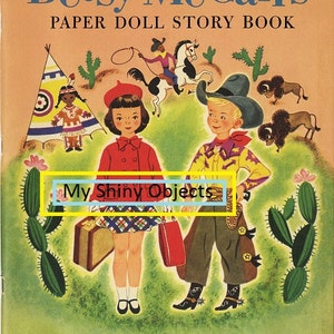 May include: A vintage book cover featuring a colorful illustration of two paper dolls, a girl and a boy, dressed in Western attire. The book title is "Betsy McCall's Paper Doll Story Book" and the text "My Shiny Objects" is visible below the dolls.