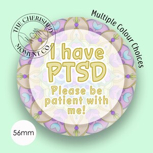 Può includere: Una spilla rotonda con un diametro di 56 mm. Il design presenta un colorato motivo mandala nelle tonalità del viola, blu e marrone chiaro. Il testo in oro recita: I have PTSD Please be patient with me! È visibile il logo di The Cherished Moment Co.