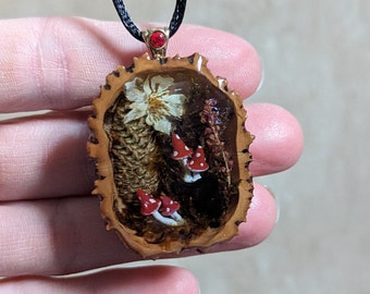 Magical forest scene with mushrooms, pinecone, plants and flowers Black walnut shell epoxy resin pendant necklace Fairy tale jewelry