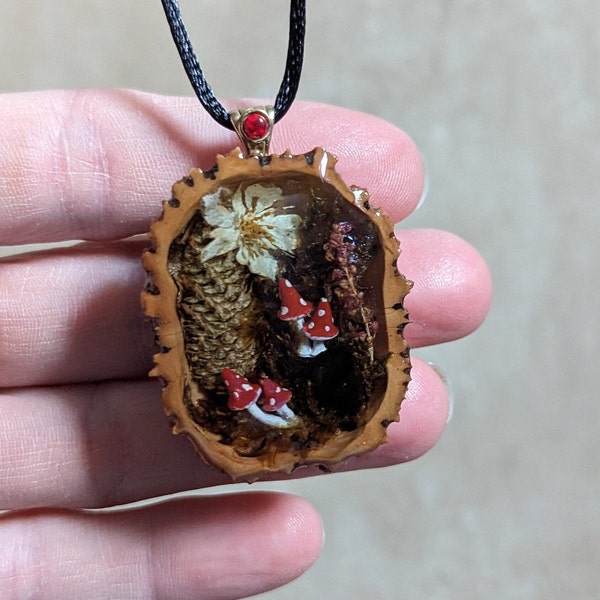 Magical forest scene with mushrooms, pinecone, plants and flowers Black walnut shell epoxy resin pendant necklace Fairy tale jewelry