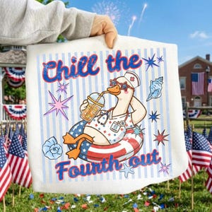 Könnte beinhalten: Eine weiße Tragetasche mit dem Text "Chill the Fourth out" und einer Cartoon-Gans mit Sonnenbrille, Krankenschwesteruniform und Schwimmring. Die Gans trinkt aus einem Getränkebecher. Der Hintergrund hat blau-weiße Streifen, Sterne und Muscheln.
