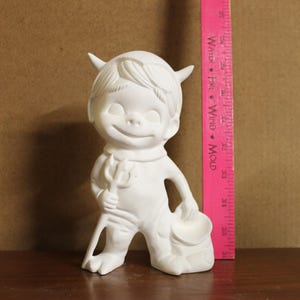 May include: White ceramic figurine of a devil with horns, a trident, and a bucket. The figurine is approximately 6 inches tall.