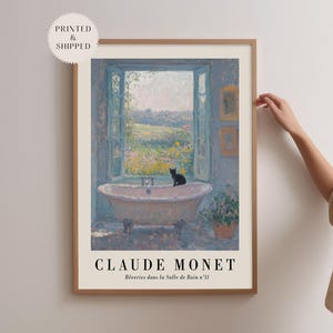May include: A framed art print of a Claude Monet painting. The artwork shows a bathtub in front of an open window with a view of a landscape. A black cat is on the tub. The text "CLAUDE MONET" is at the bottom.