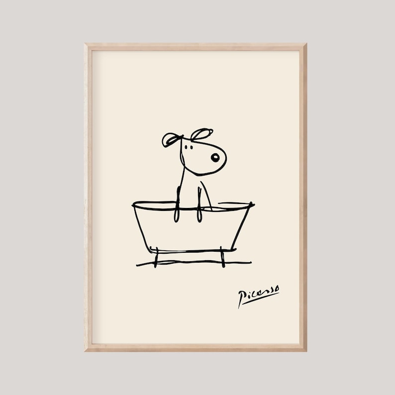 May include: A framed art print featuring a whimsical line drawing of a dog in a bathtub. The black ink illustration is set against a cream background, with the artist's signature in the lower right corner. The artwork has a minimalist style.