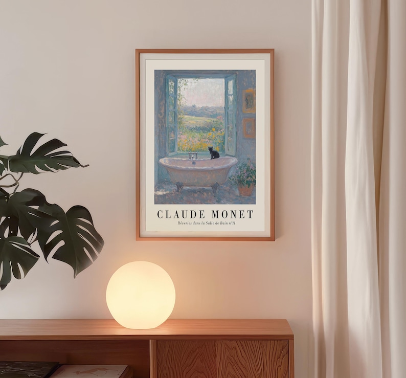 May include: A framed print of Claude Monet's "R&ecirc;veries dans la Salle de Bain n&deg;11" depicting a bathtub with a black cat, overlooking a landscape. The print is in a wooden frame, with text at the bottom.