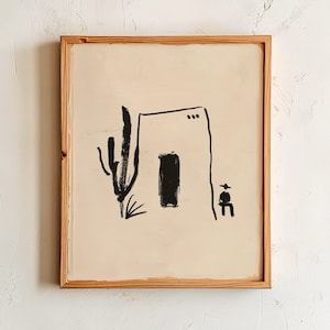 Può includere: Una stampa artistica incorniciata con una scena desertica minimalista in bianco e nero. L'opera raffigura un semplice edificio in stile adobe, un cactus e una figura, il tutto reso con audaci linee nere su sfondo beige. La cornice è in legno naturale.
