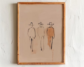 May include: An abstract art print showing three figures in cowboy hats, sketched in black on a beige background. The artwork is framed in a natural wood frame. The figures are depicted with simple lines and shading, creating a minimalist aesthetic.