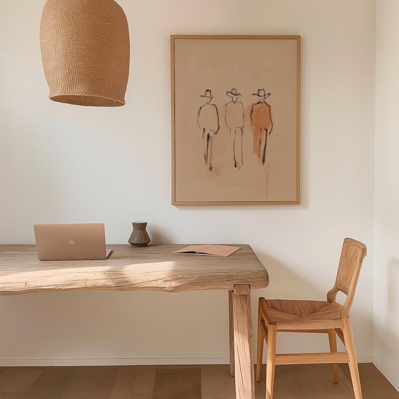 Puede incluir: Un espacio de oficina en casa de tonos neutros con un escritorio de madera, un port&aacute;til y una silla de mimbre. Una obra de arte enmarcada con figuras abstractas cuelga de la pared. Una l&aacute;mpara colgante tejida cuelga sobre el escritorio. Un peque&ntilde;o jarr&oacute;n y un cuaderno est&aacute;n sobre el escritorio.