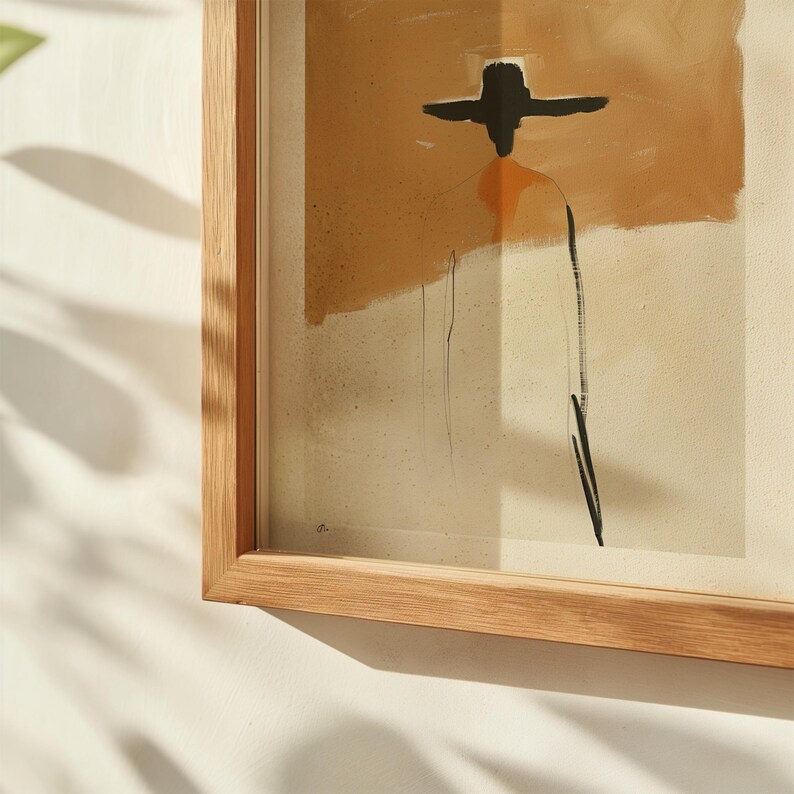 K&ouml;nnte beinhalten: Abstrakter Kunstdruck in einem Naturholzrahmen. Das Kunstwerk zeigt eine Figur mit Hut, dargestellt in schwarzen Linien und orangefarbener und beigefarbener Farbe. Das Kunstwerk ist in hellem Holz gerahmt.