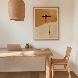 K&ouml;nnte beinhalten: Ein modernes Homeoffice-Setup mit einem Holztisch, einem Laptop und einem Stuhl aus Korbgeflecht. Ein gerahmtes abstraktes Kunstwerk h&auml;ngt an der Wand. Eine gewebte Leuchte h&auml;ngt &uuml;ber dem Schreibtisch. Eine kleine Vase und ein Notizbuch befinden sich auf dem Schreibtisch.