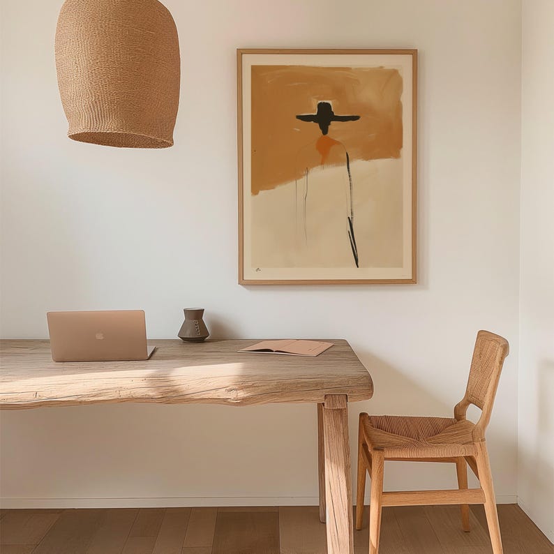K&ouml;nnte beinhalten: Ein modernes Homeoffice-Setup mit einem Holztisch, einem Laptop und einem Stuhl aus Korbgeflecht. Ein gerahmtes abstraktes Kunstwerk h&auml;ngt an der Wand. Eine gewebte Leuchte h&auml;ngt &uuml;ber dem Schreibtisch. Eine kleine Vase und ein Notizbuch befinden sich auf dem Schreibtisch.