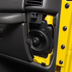 Può includere: Primo piano dell'interno di una portiera di un'auto con un altoparlante nero e un pannello porta giallo. L'altoparlante è montato in una cornice nera e il pannello della porta è giallo brillante. L'altoparlante ha un centro nero con una "X" bianca.