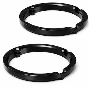May include: Two black, circular speaker rings with a beveled edge and mounting holes. The rings are made of a solid material and have a smooth, matte finish. The design is simple and functional, suitable for audio equipment.