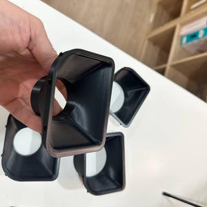 May include: A set of four black, 3D-printed plastic funnel-shaped components with a rectangular opening that tapers down to a circular aperture. Each piece features a smooth interior surface and a slightly textured exterior finish.