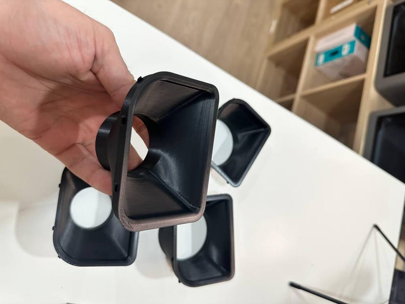 May include: A set of four black, 3D-printed plastic funnel-shaped components with a rectangular opening that tapers down to a circular aperture. Each piece features a smooth interior surface and a slightly textured exterior finish.