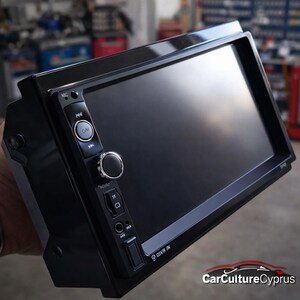 Può includere: Un'autoradio nera con un ampio display touchscreen. Ha diversi pulsanti e una manopola di controllo sul pannello frontale. L'autoradio è rettangolare e sembra nuova.