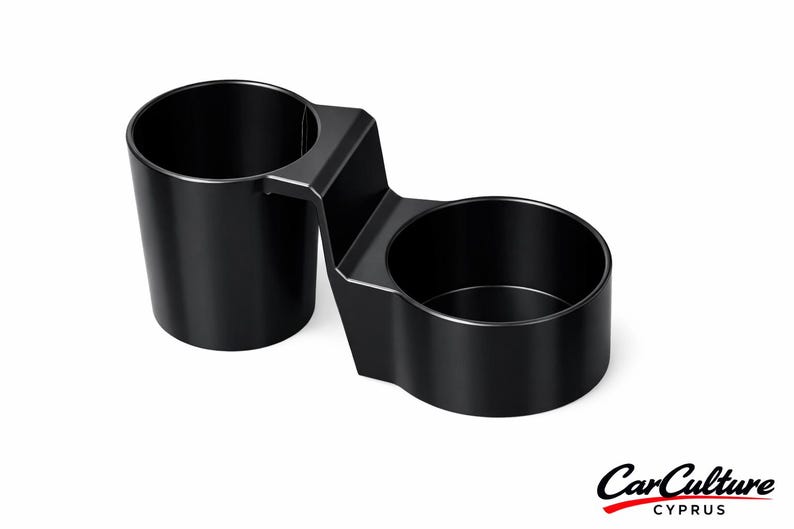 May include: A black dual cup holder featuring two cylindrical compartments connected by a central bridge. The unit has a smooth, matte finish and a rigid structure. The text CarCulture CYPRUS is printed in the bottom right corner of the image.