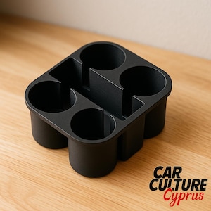 Puede incluir: Un organizador de consola de coche negro con cuatro portavasos y compartimentos de almacenamiento adicionales. El organizador está hecho de un material negro mate y se encuentra sobre una superficie de madera. El texto "CAR CULTURE Cyprus" es visible.