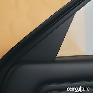 Op de afbeelding: Close-up van een zwart autodeurframe en raamlijst. De afbeelding benadrukt de scherpe hoeken en texturen van de interieurcomponenten van de auto. Het carculture-logo is zichtbaar in de rechterbenedenhoek.