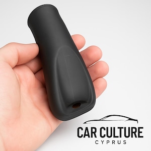 Könnte beinhalten: Ein schwarzes Autozubehör mit zylindrischem Oberteil und konturiertem Körper. Das Zubehör wird in einer Hand vor weißem Hintergrund gehalten. Der Text "CAR CULTURE CYPRUS" ist in der unteren rechten Ecke sichtbar.